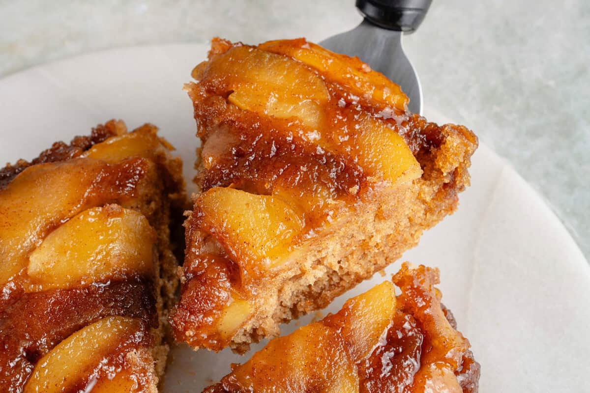 close up of a lifted slice of caramel apple upside down cake