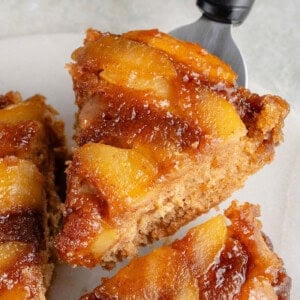 close up of a lifted slice of caramel apple upside down cake