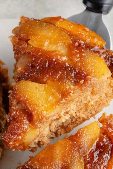 close up of a lifted slice of caramel apple upside down cake
