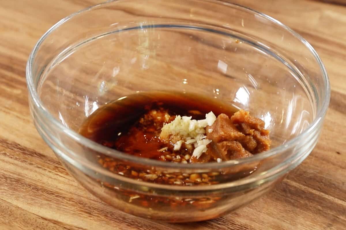 adding miso and garlic to the bowl