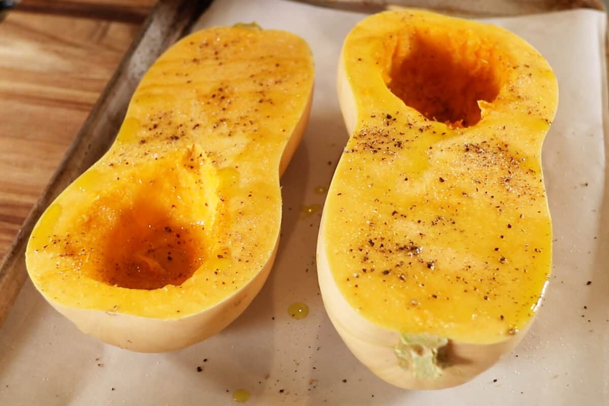 butternut squash seasoned with salt and pepper on a baking sheet