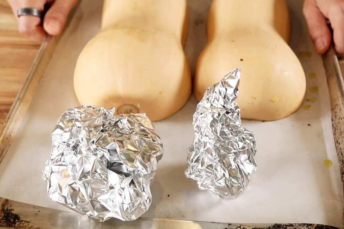 butternut squash, garlic, and shallots on a baking sheet