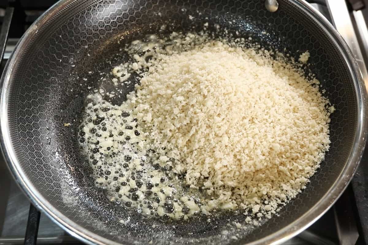 adding panko bread crumbs to melted butter