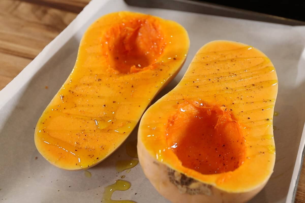 dressing a butternut squash with oil, salt and pepper