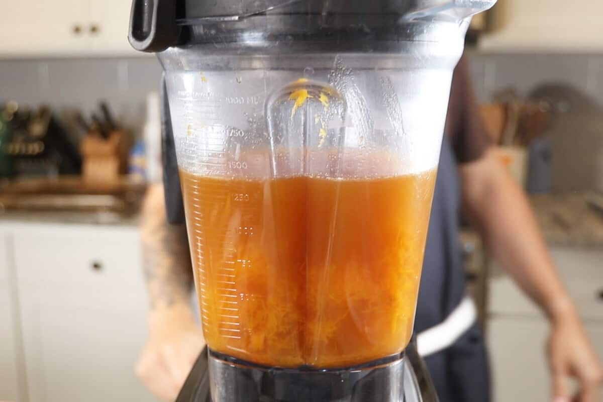 adding broth and butternut squash to the blender