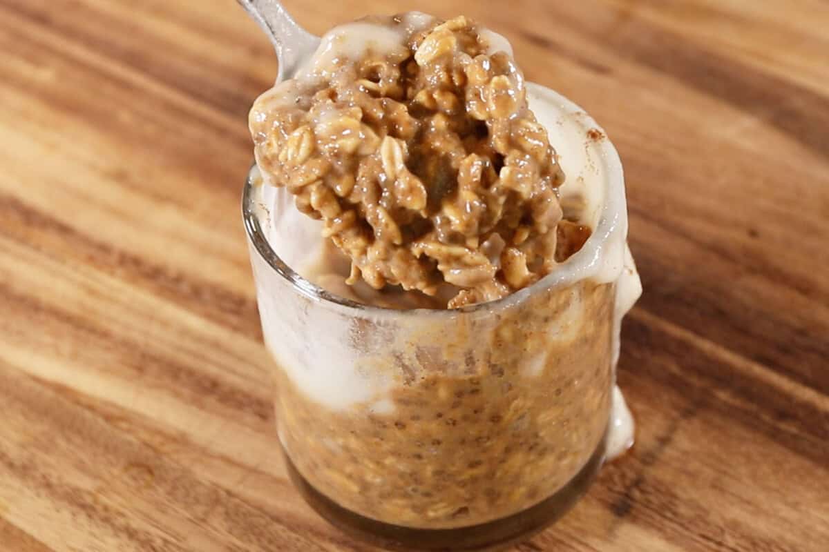 spoonful of pumpkin chai latte overnight oats being lifted out of glass