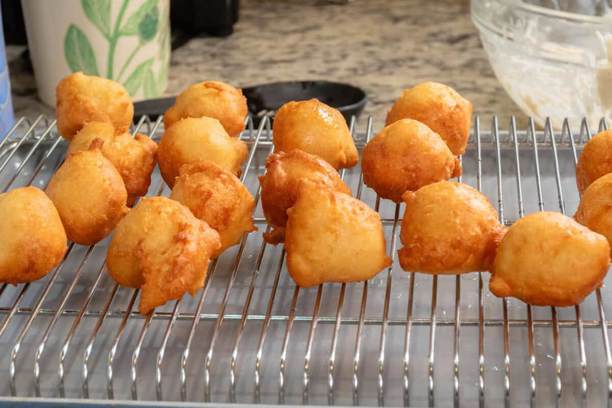 freshly fried zeppole on cooling rack