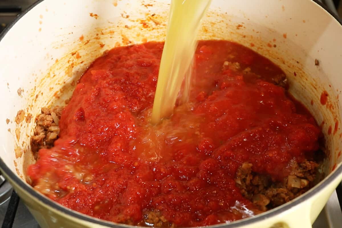 adding broth to the pot