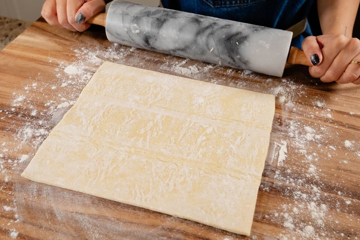 thawed puff pastry dough on floured work surface