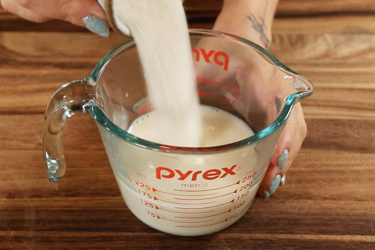 adding sugar to measuring cup