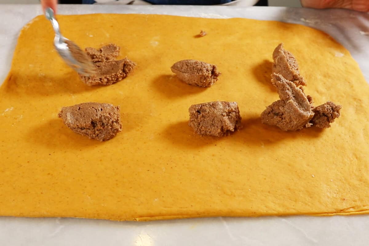 dolloping cinnamon filling onto dough
