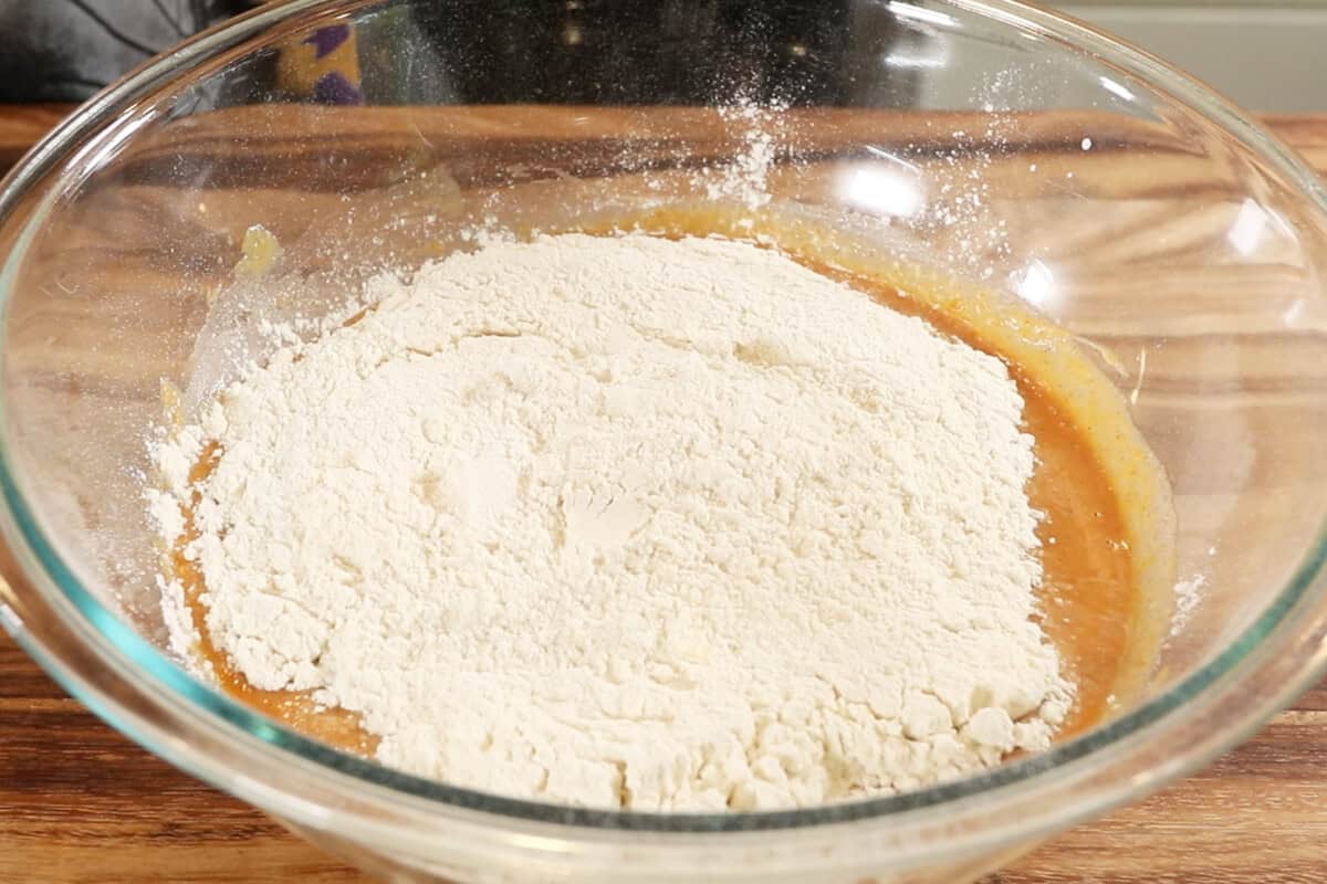 adding flour to wet ingredients in large bowl