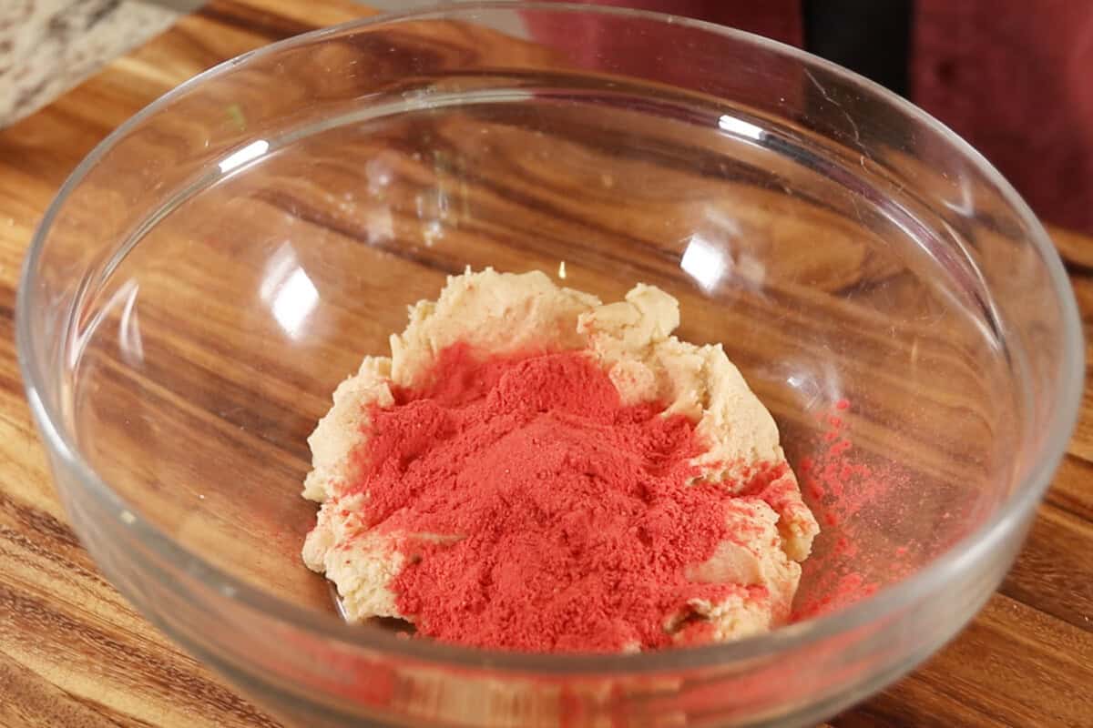 glass bowl of ground freeze-dried strawberries on sugar cookie dough