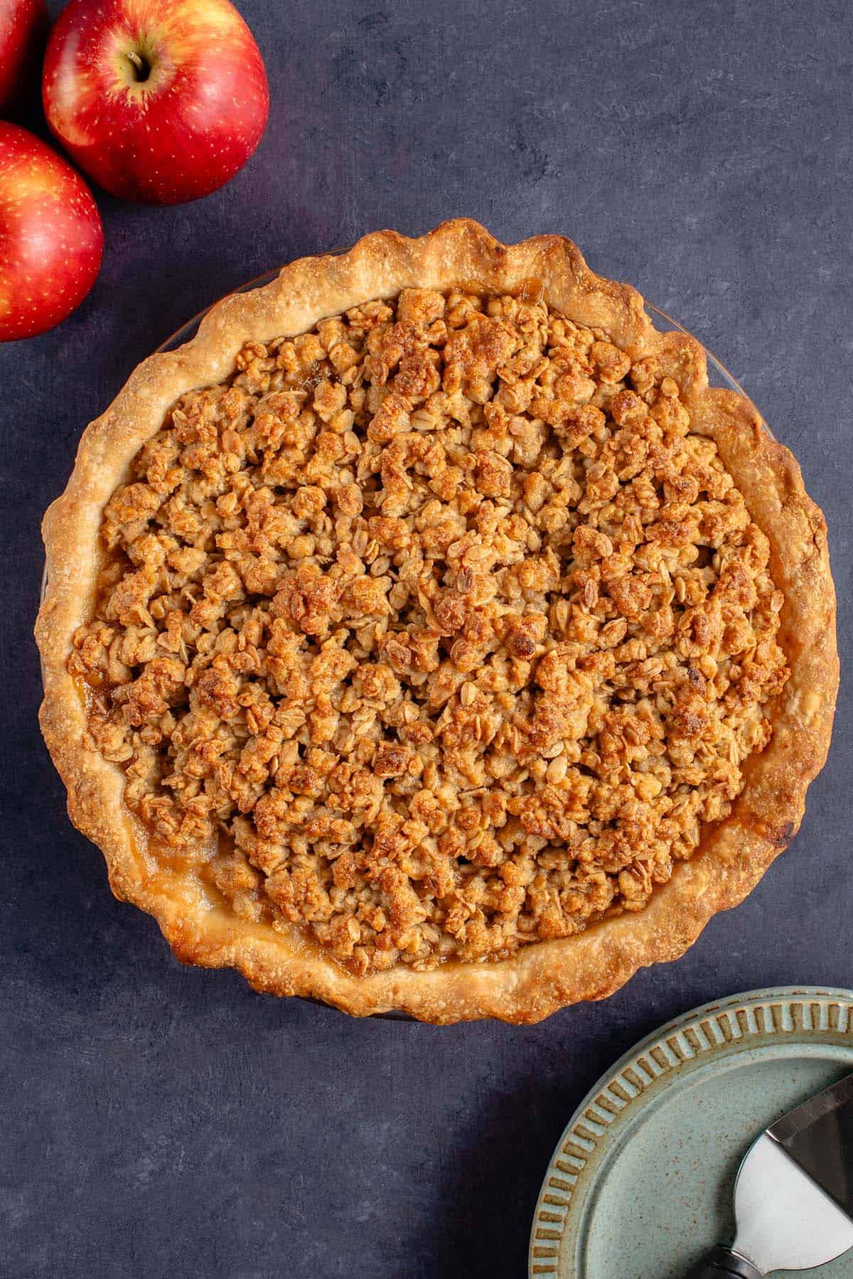 baked apple crumble pie with apples peaking in