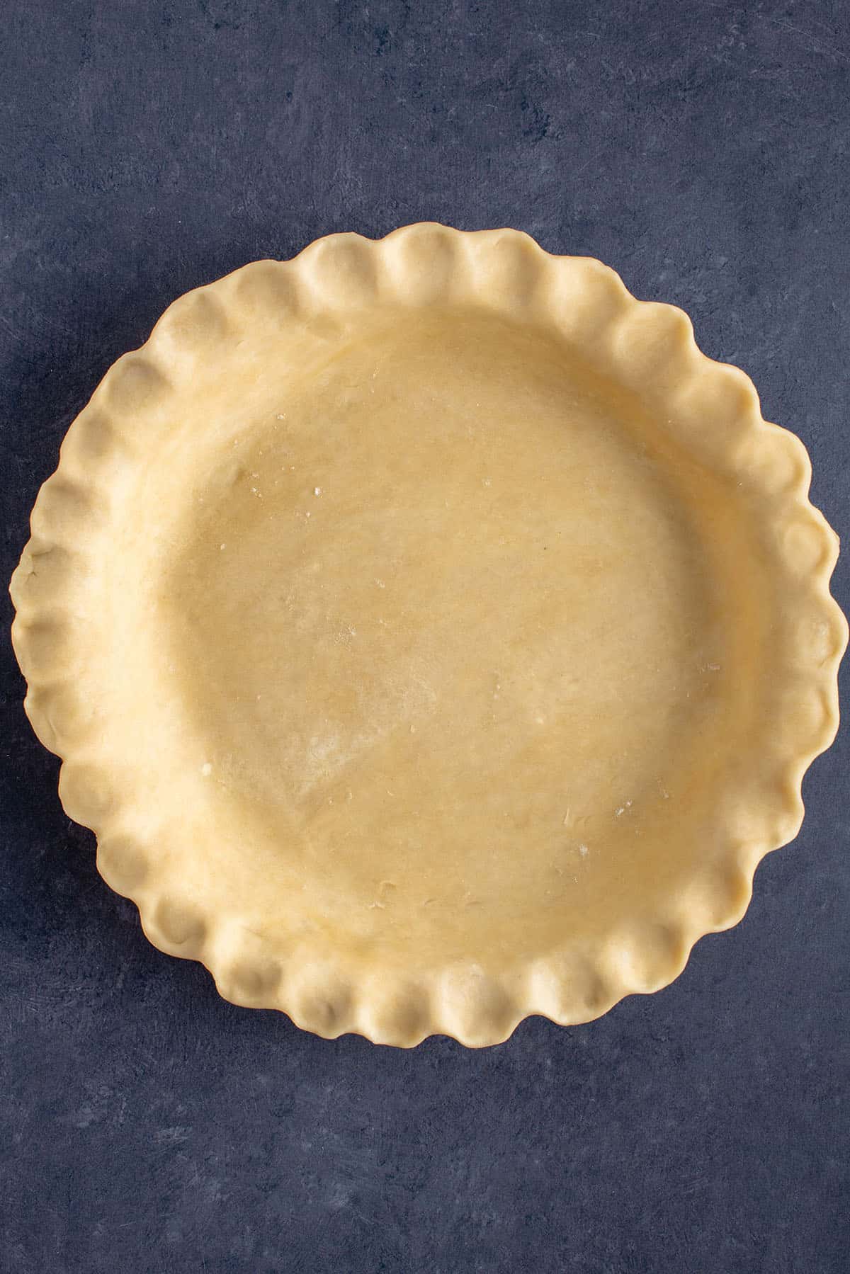 unbaked pie dough on a blue background