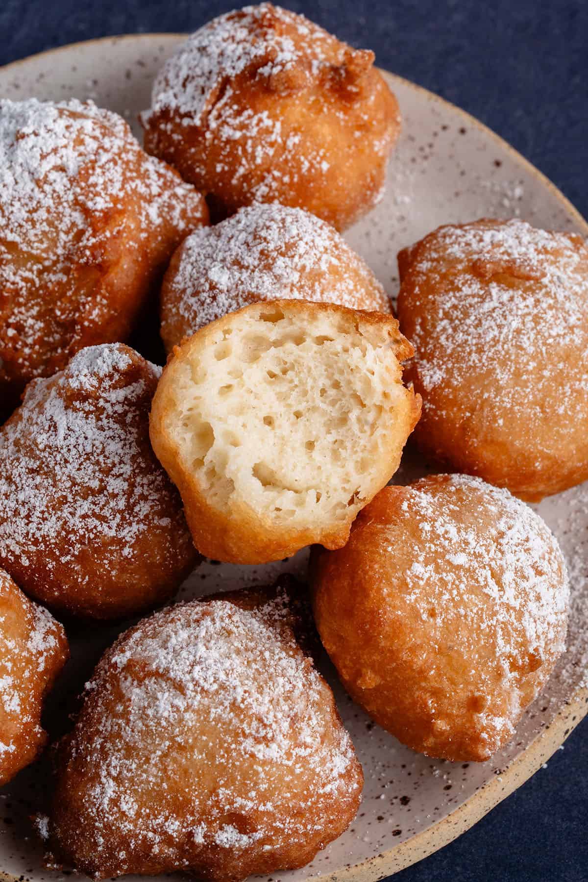 zeppole on plate with one bitten on top