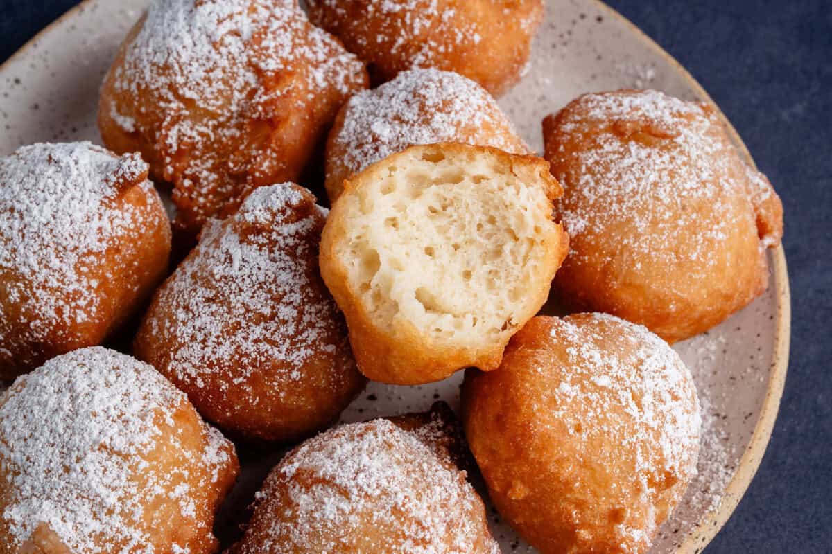 zeppole on plate with one bitten on top