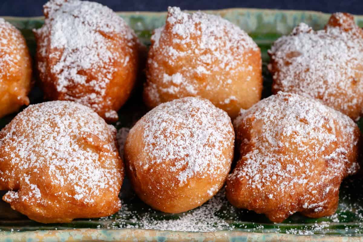 zeppole dusted with powdered sugar on a plate