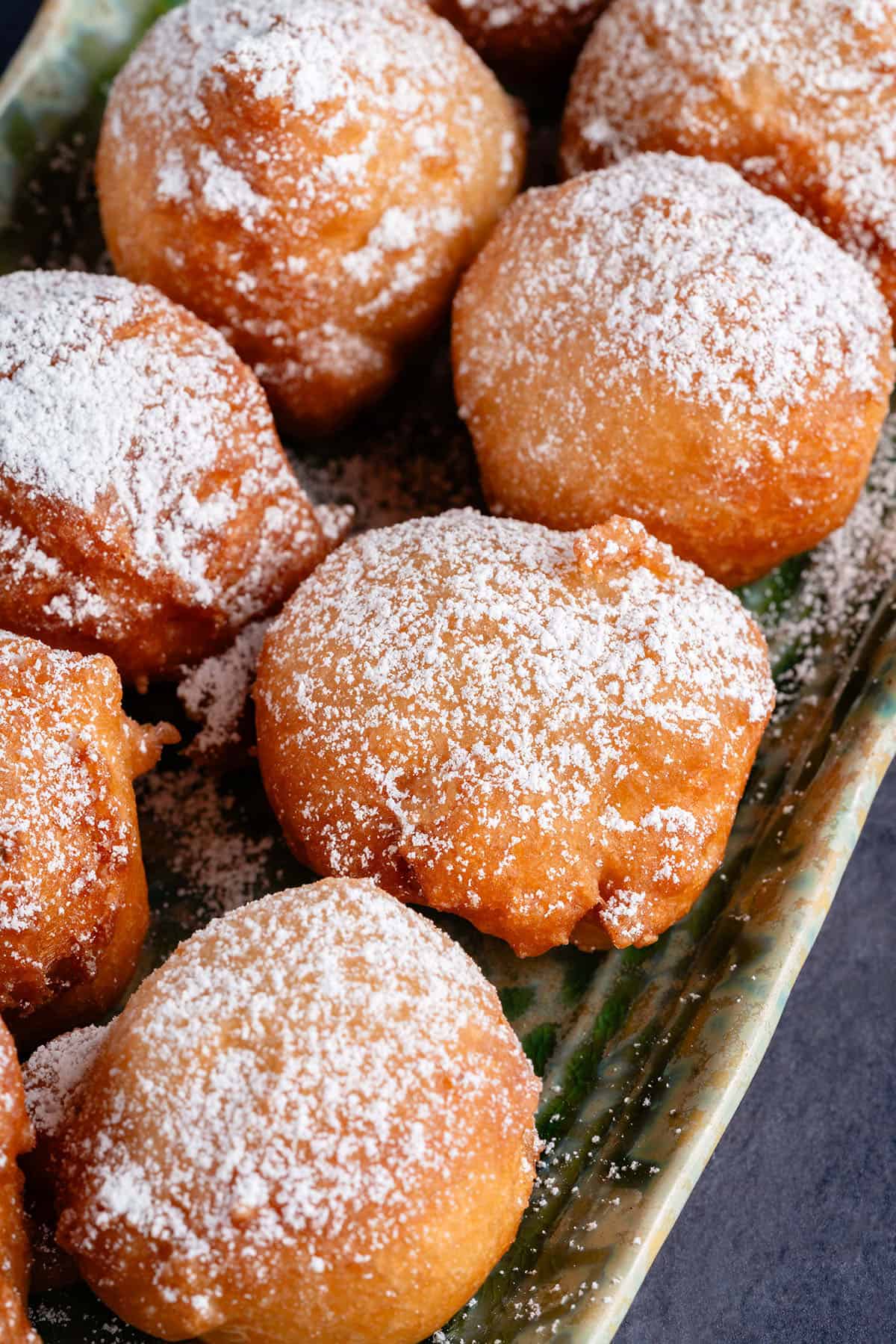 zeppole dusted with powdered sugar on a plate