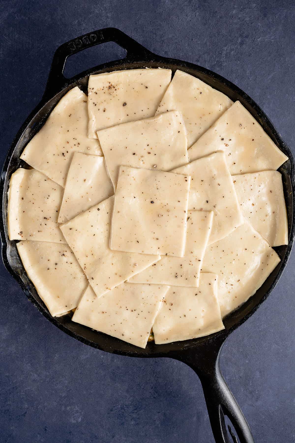 puff pastry squares with salt and pepper on top of a vegan mushroom pot pie before baking