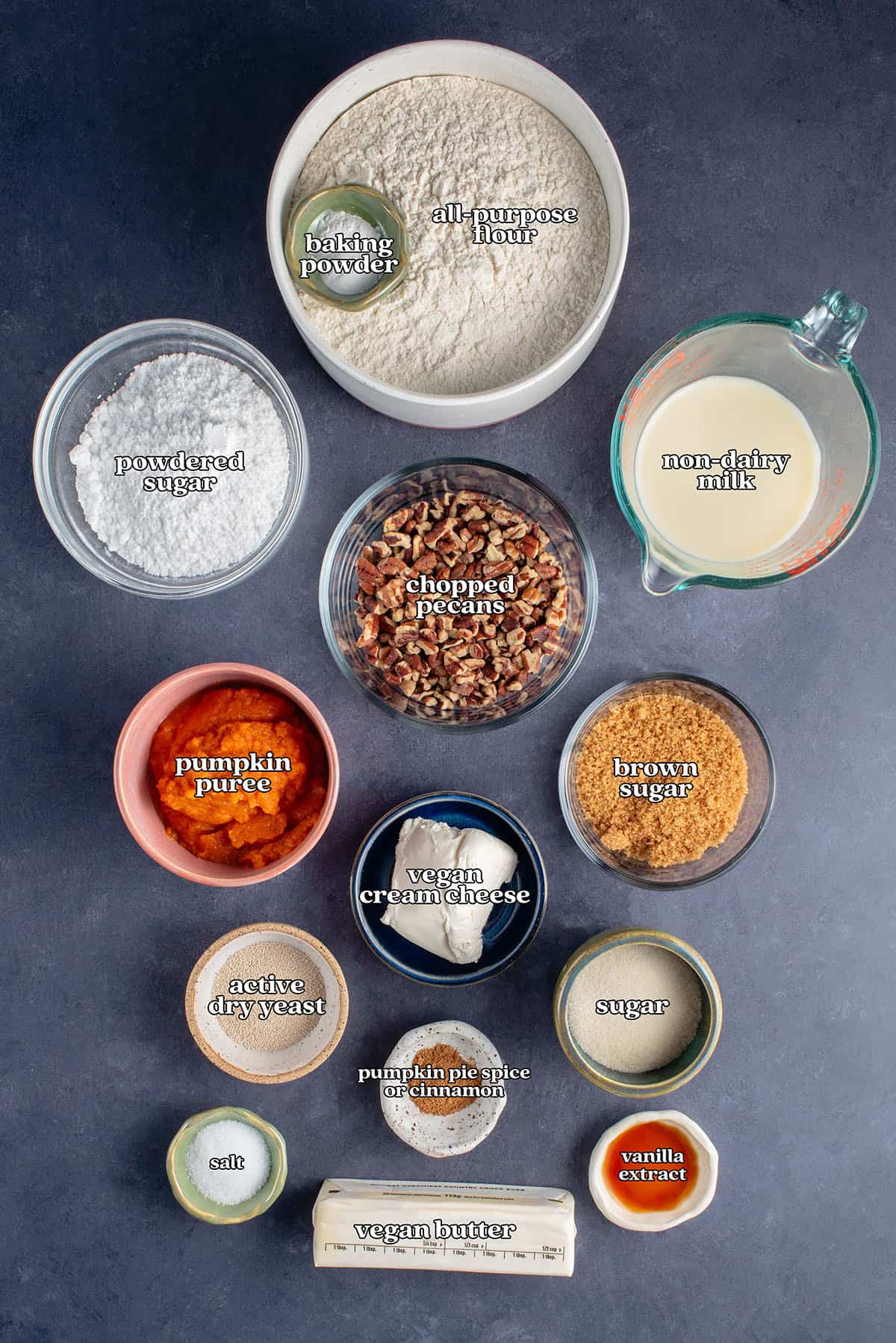 baking powder, all-purpose flour, powdered sugar, non-dairy milk, chopped pecans, pumpkin puree, brown sugar, vegan cream cheese, active dry yeast, sugar. pumpkin pie spice or cinnamon, salt, vegan butter, vanilla extract