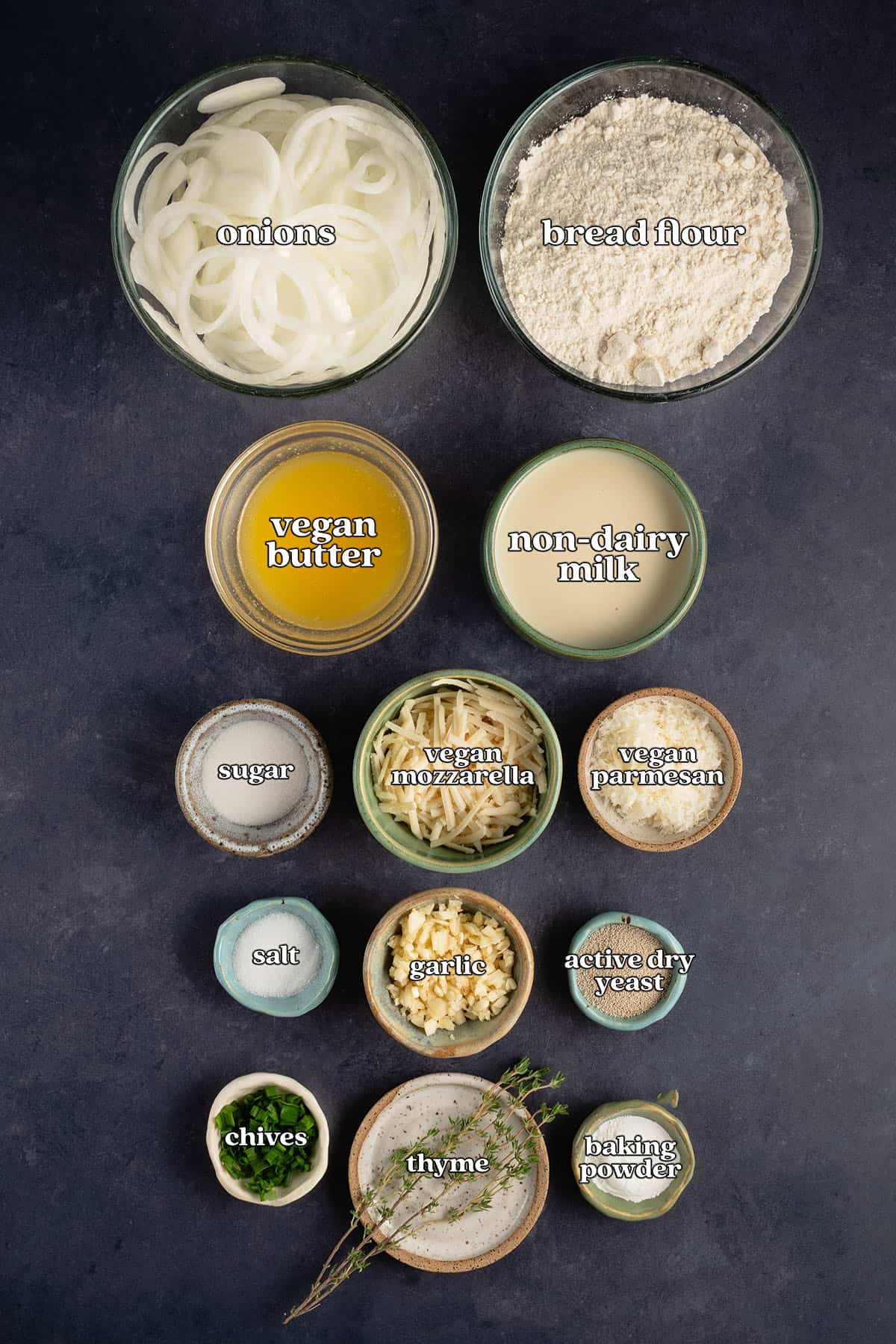 labeled ingredients for french onion pull part bread: onions, bread flour, vegan butter, non-dairy milk, sugar, vegan mozzarella, vegan parmesan, salt, garlic, active dry yeast, chives, thyme and baking powder