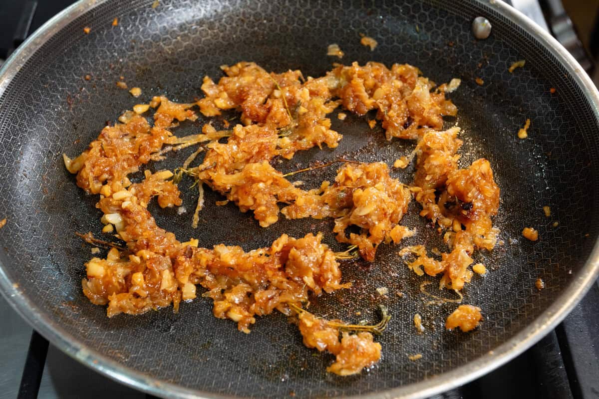 caramelized onions in large black pan with garlic and thyme