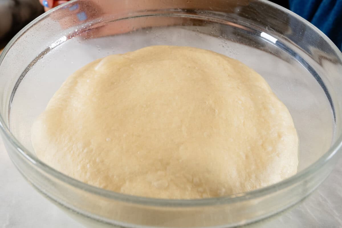 risen dough in large glass bowl