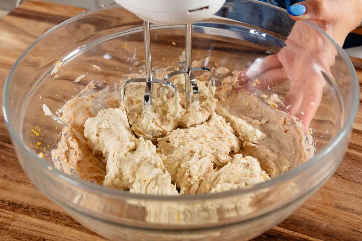 using a hand mixer to whip cannoli cream