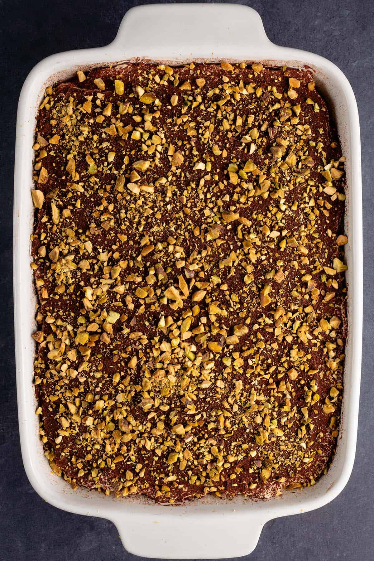 a tray of vegan cannoli tiramisu before being cut