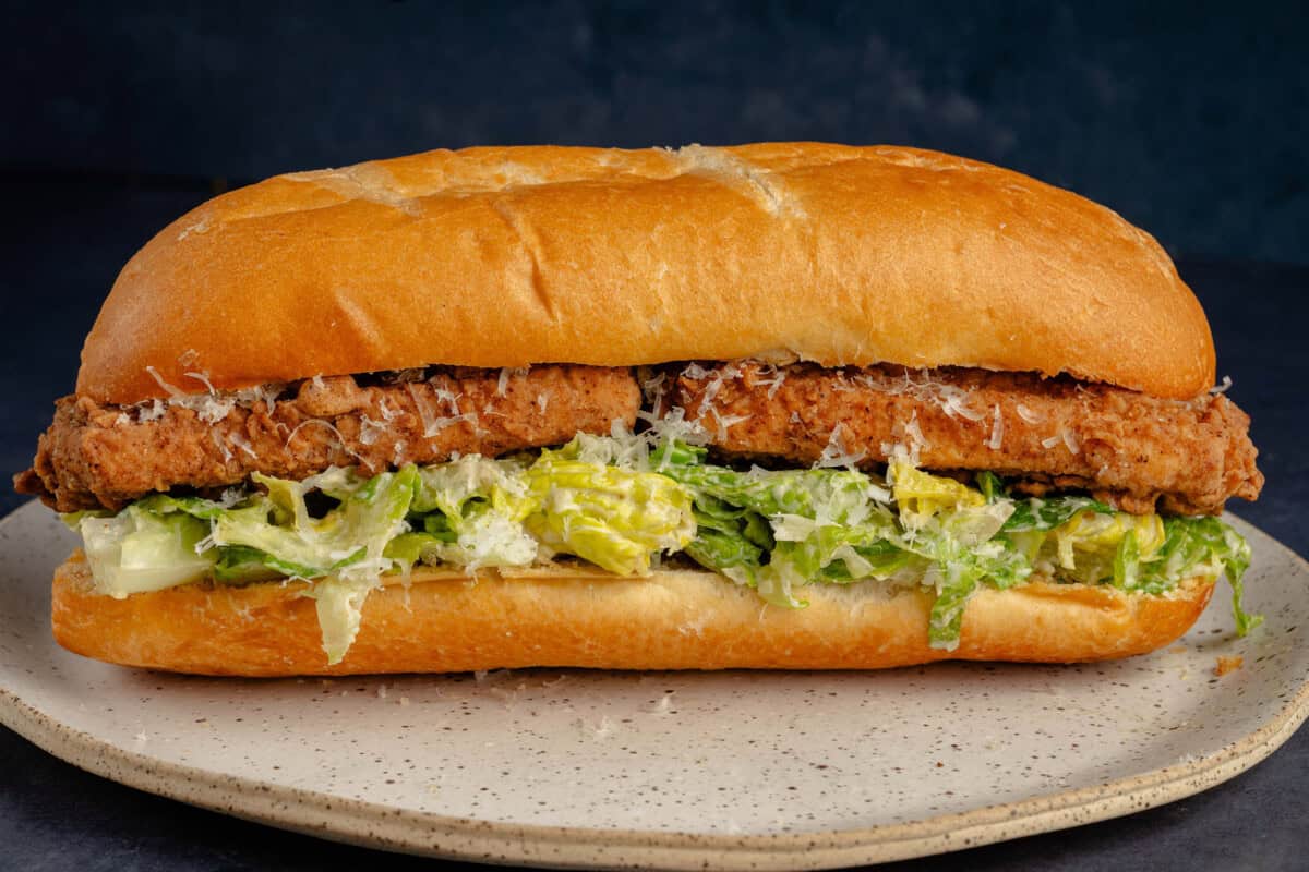 tofu fried chicken caesar salad sandwich on a plate