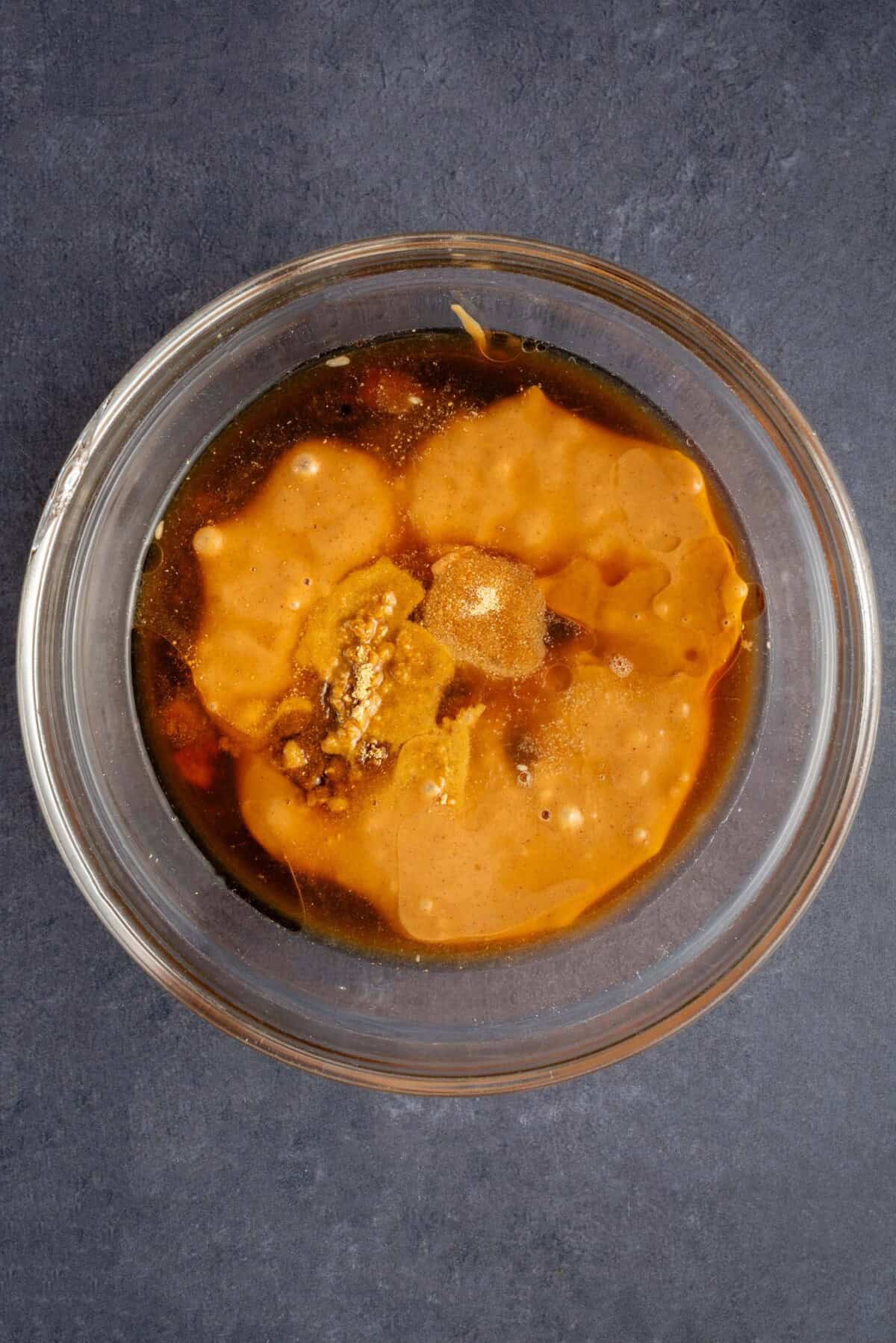 ingredients for peanut sauce in glass bowl before mixing