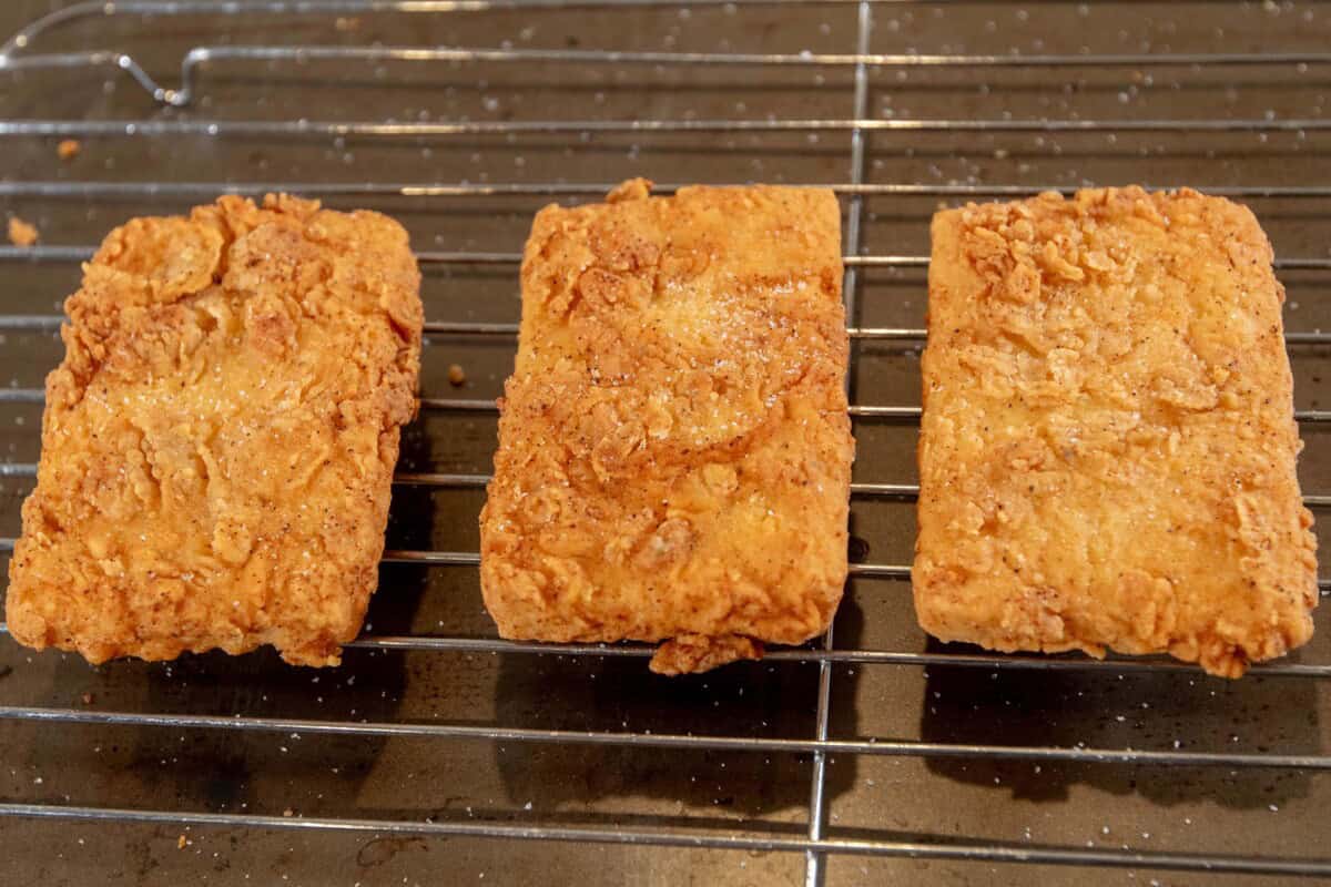 finished fried tofu cutlets on a wire rack coated with salt