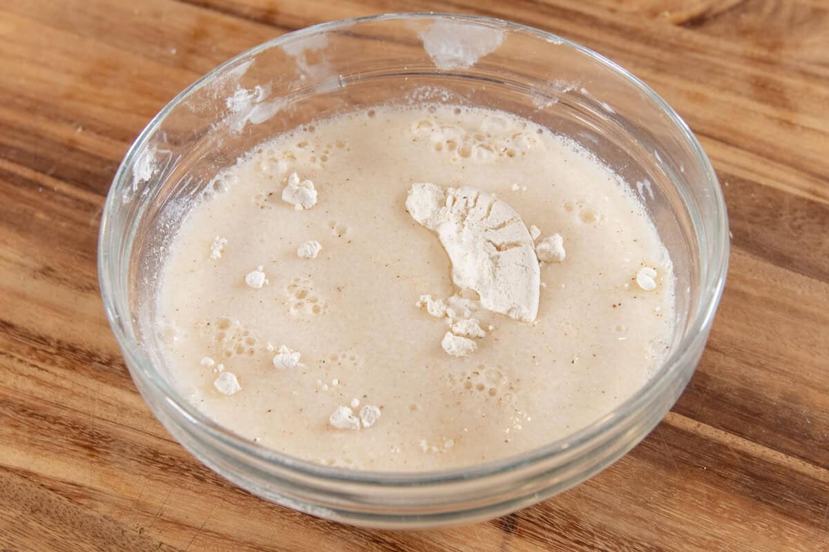 adding liquid to the bowl to create the batter