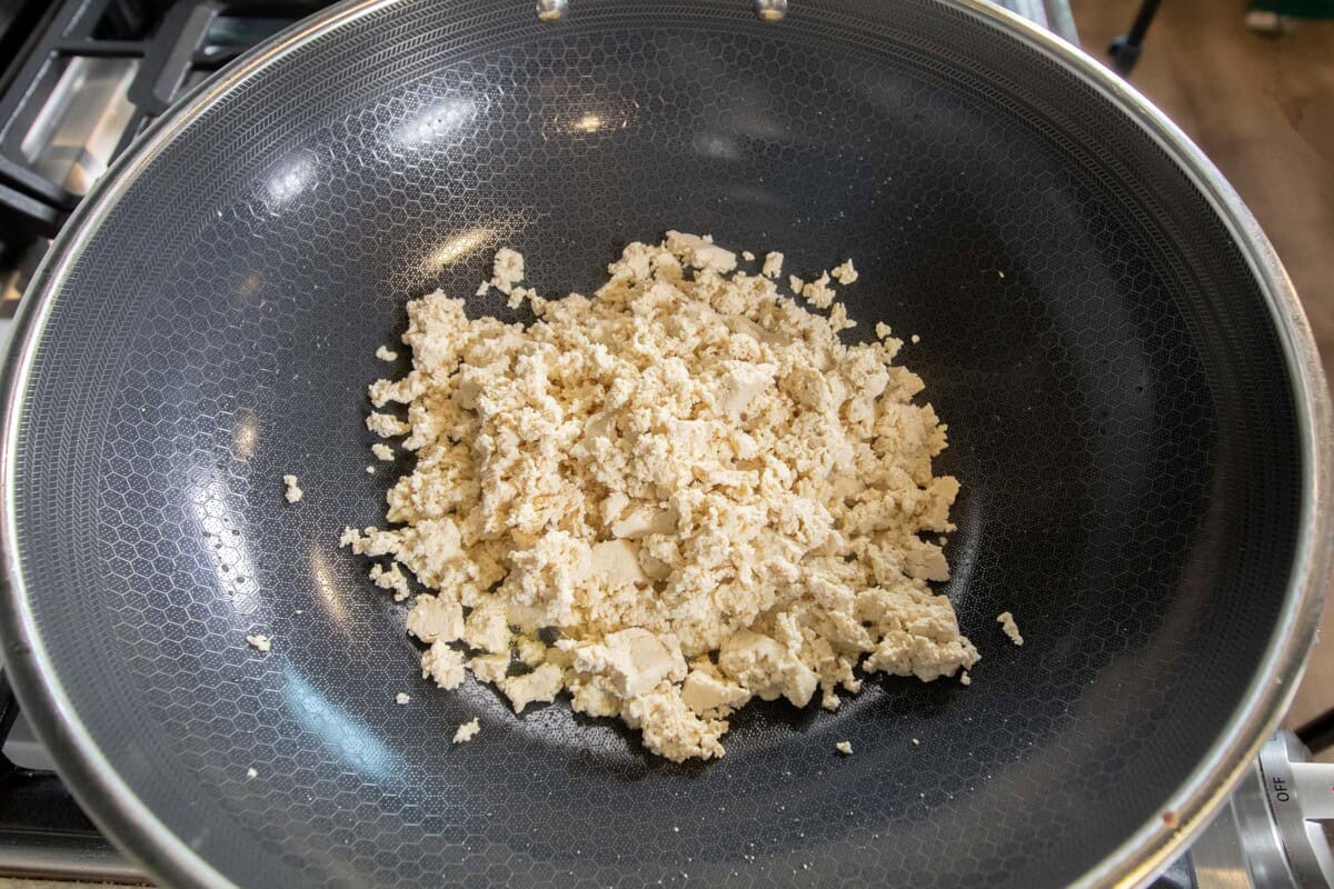 adding tofu to a large skillet