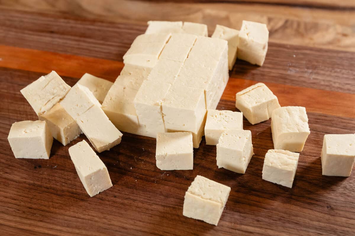 pieces of cubes extra firm tofu on wooden cutting board