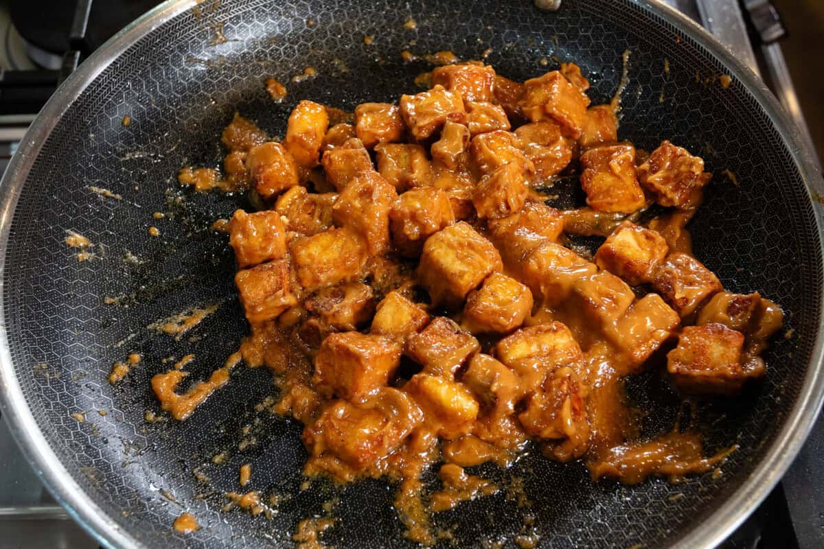 creamy peanut tofu in black hexclad pan