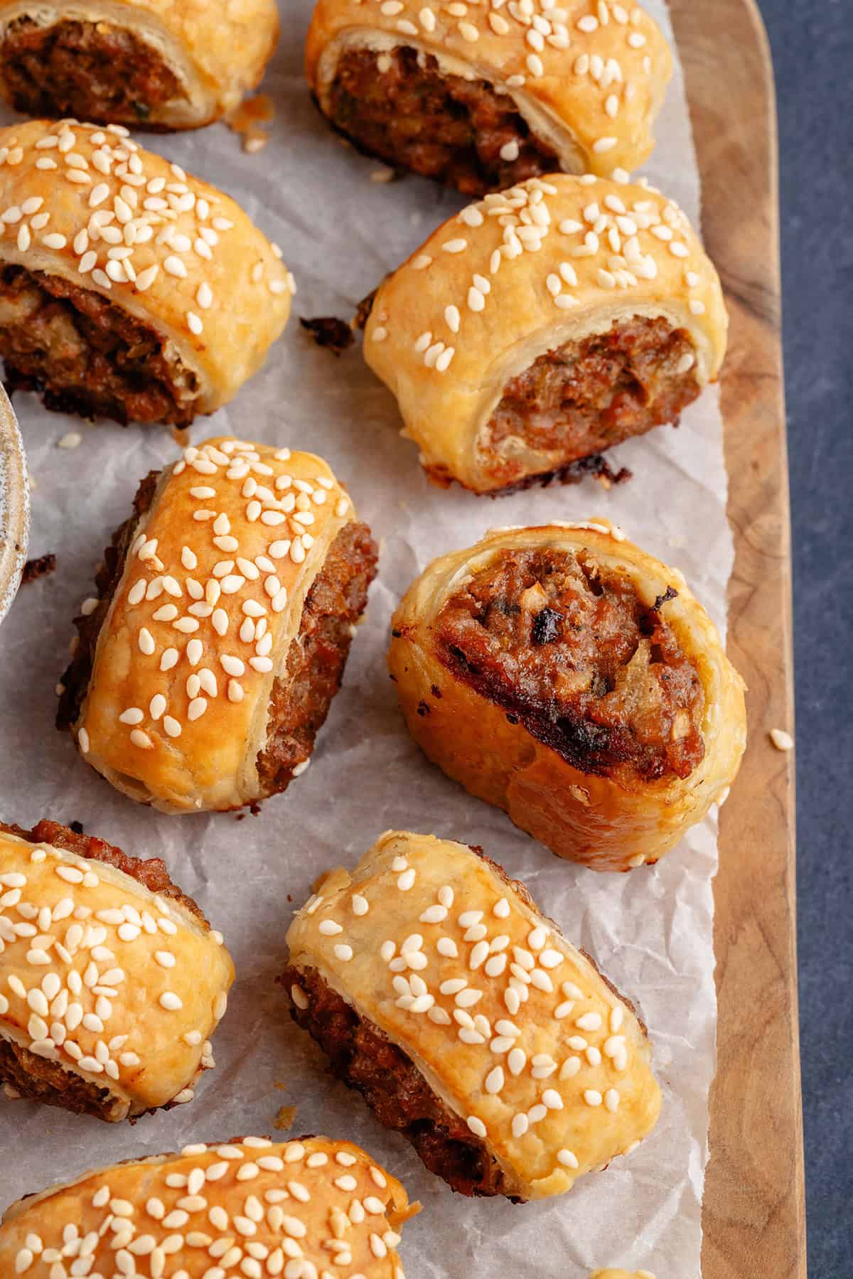 sausage rolls on a wooden board and parchment paper