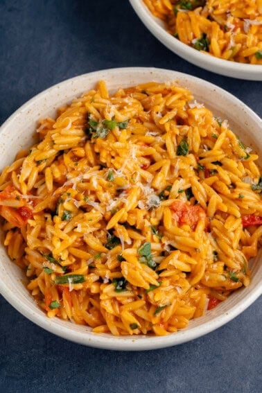 bowl of one pot creamy tomato orzo topped with vegan parmesan