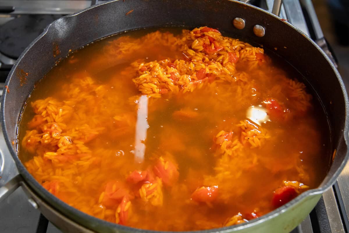 adding broth to the pan