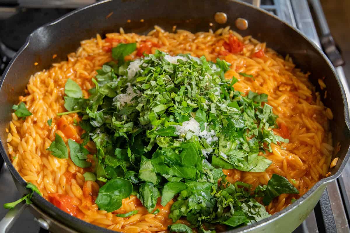 adding spinach, herbs, and parmesan