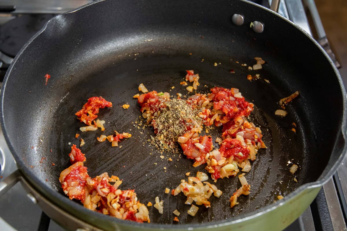 adding Italian seasoning to the pan