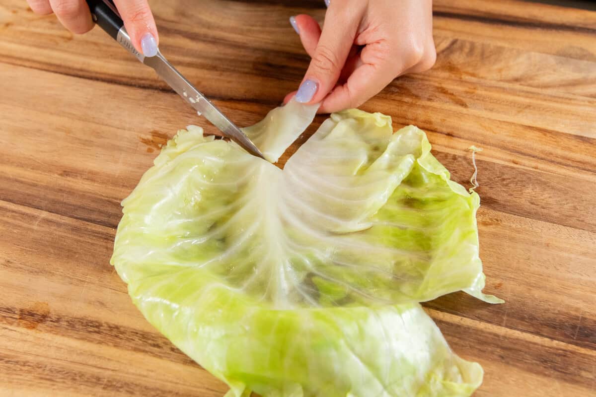 cutting off the bottom of the leaf to make it easier to roll
