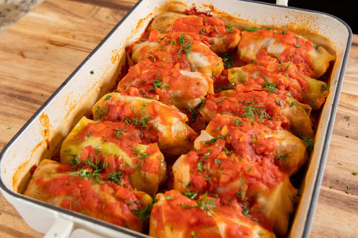 baked cabbage rolls in baking dish topped with dill