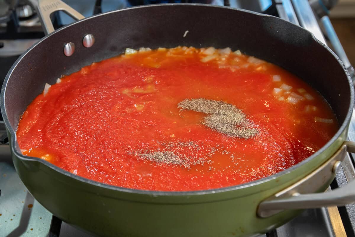 adding in tomato sauce and black pepper