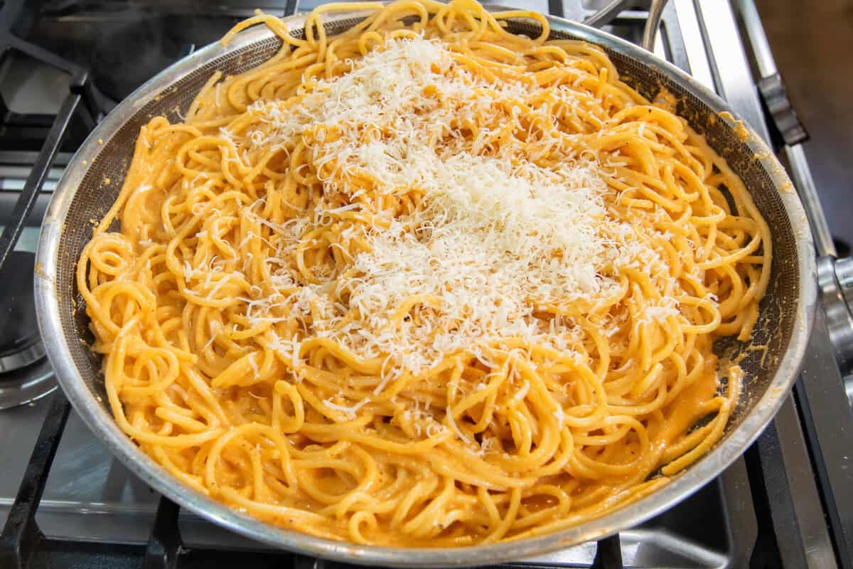 grated vegan parmesan on top of pasta in pan