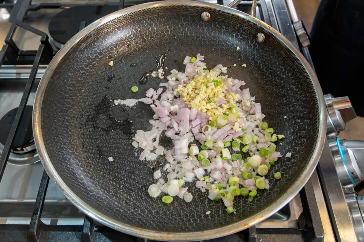 shallots, garlic and green onions in a pan before being cooked