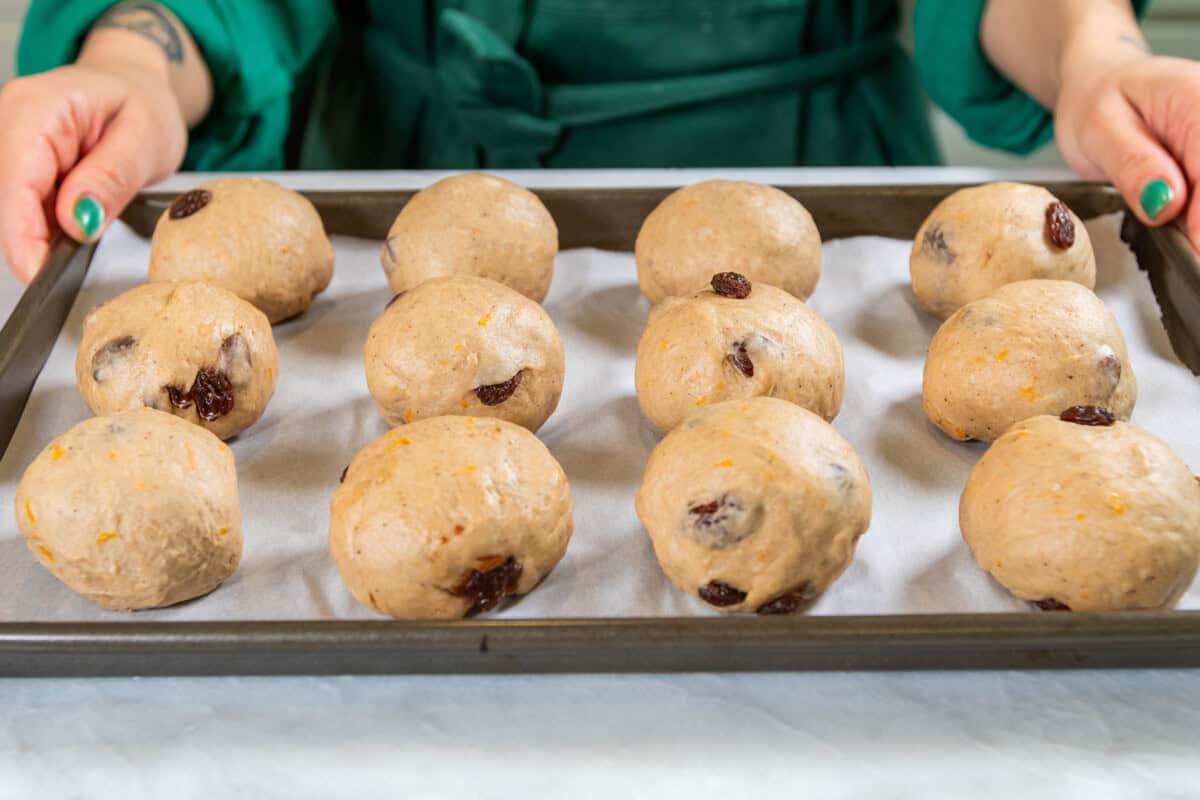 vegan hot cross buns dough balls on baking sheet before rising