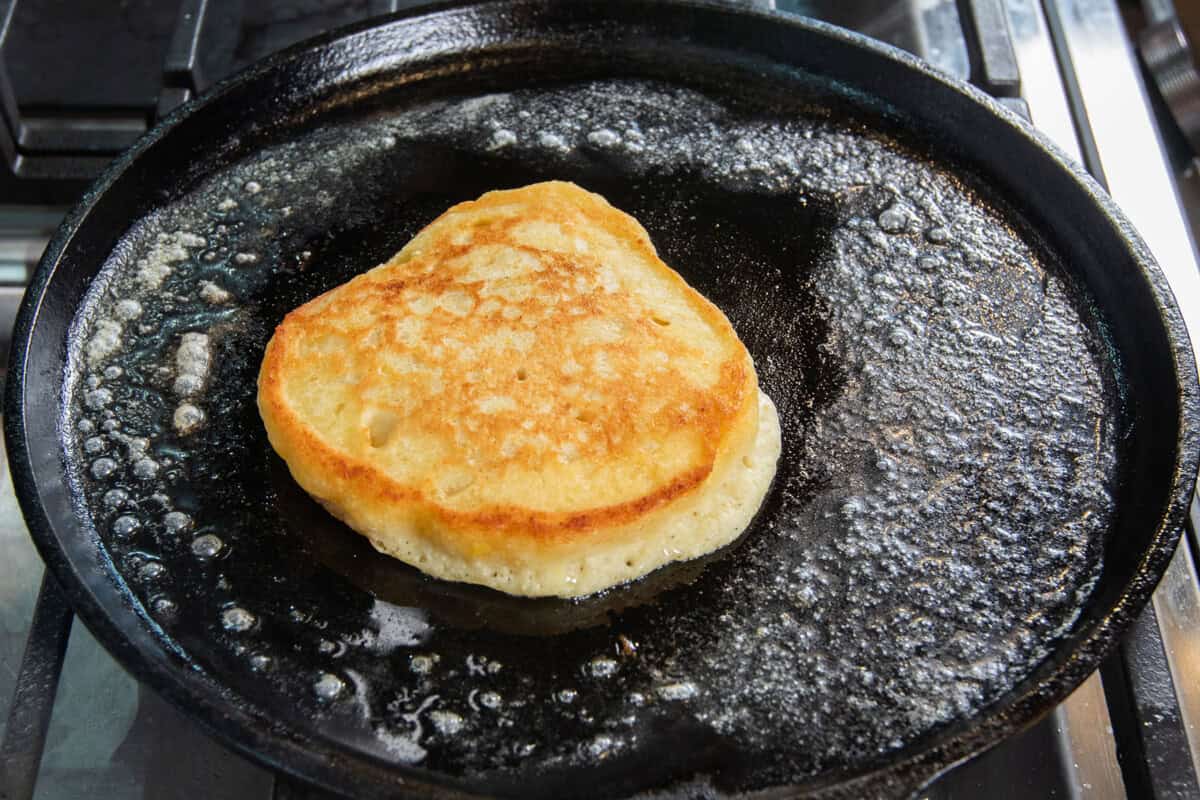 cooking a pancake on a buttered skillet