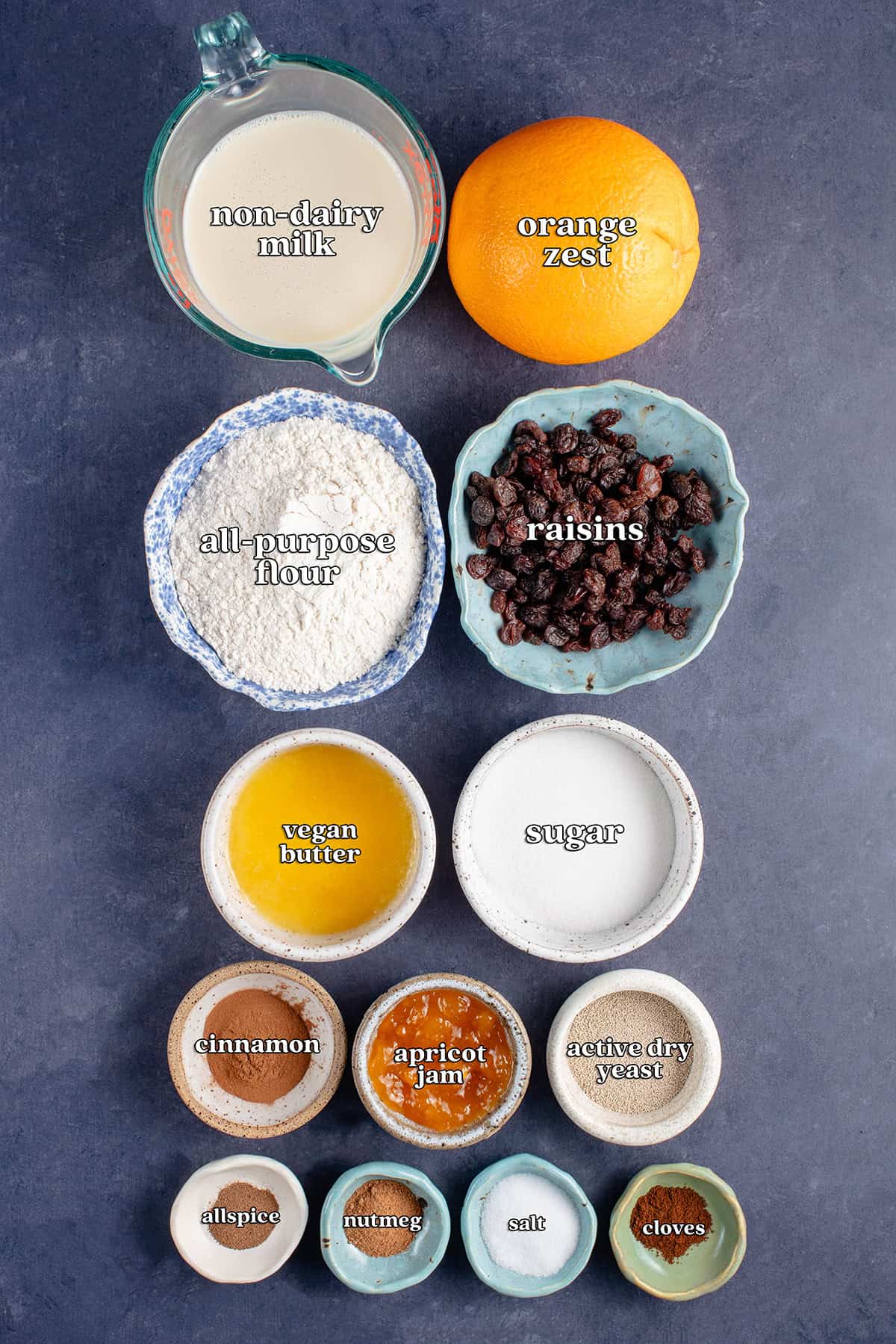 non-dairy milk, orange zest, all-purpose flour, raisins, vegan butter, sugar, cinnamon apricot jam, active dry yeast, allspice, nutmeg, salt, cloves